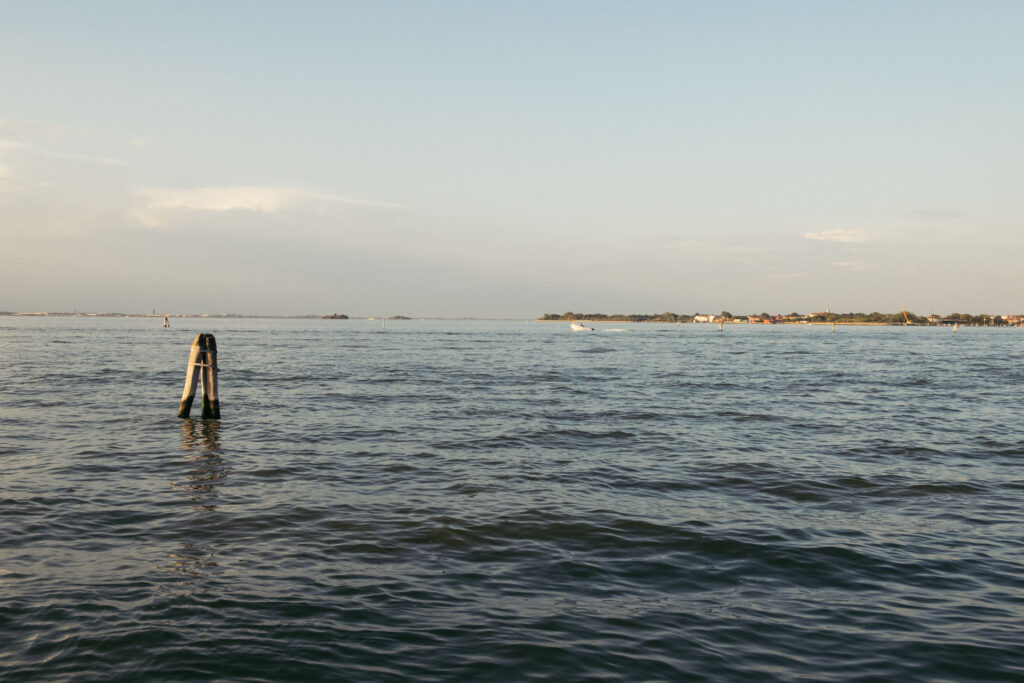 Golden hour over the Venetian Lagoon, a simple and tranquil view of the calm waters as the day comes to an end in Venice