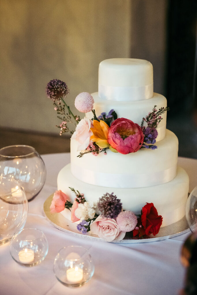 Colorful floral adornment on the wedding cake, adding a vibrant and festive touch to this delectable centerpiece of the celebration