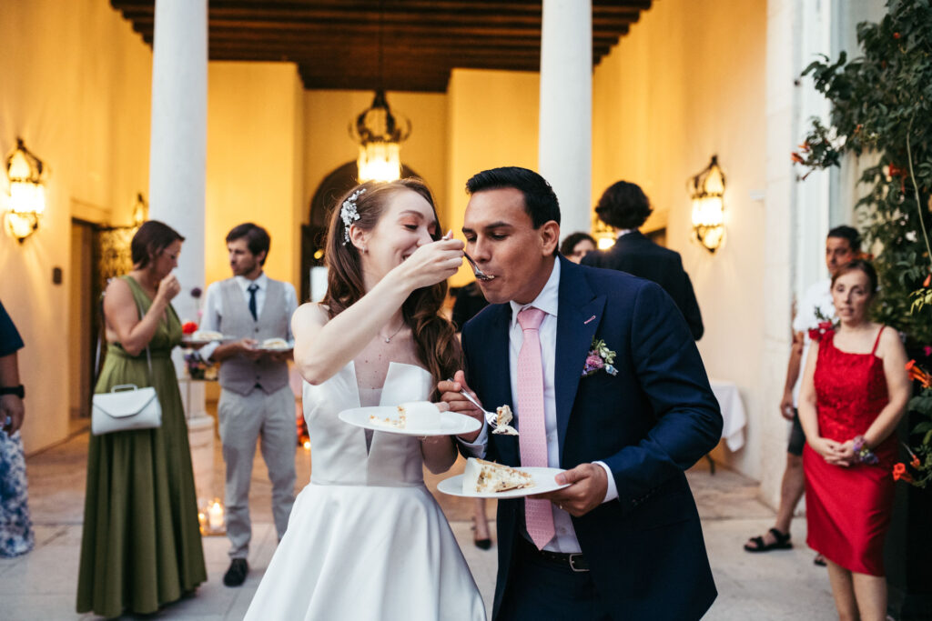 The bride and groom enjoy a delightful moment together, savoring the first bites of their wedding cake