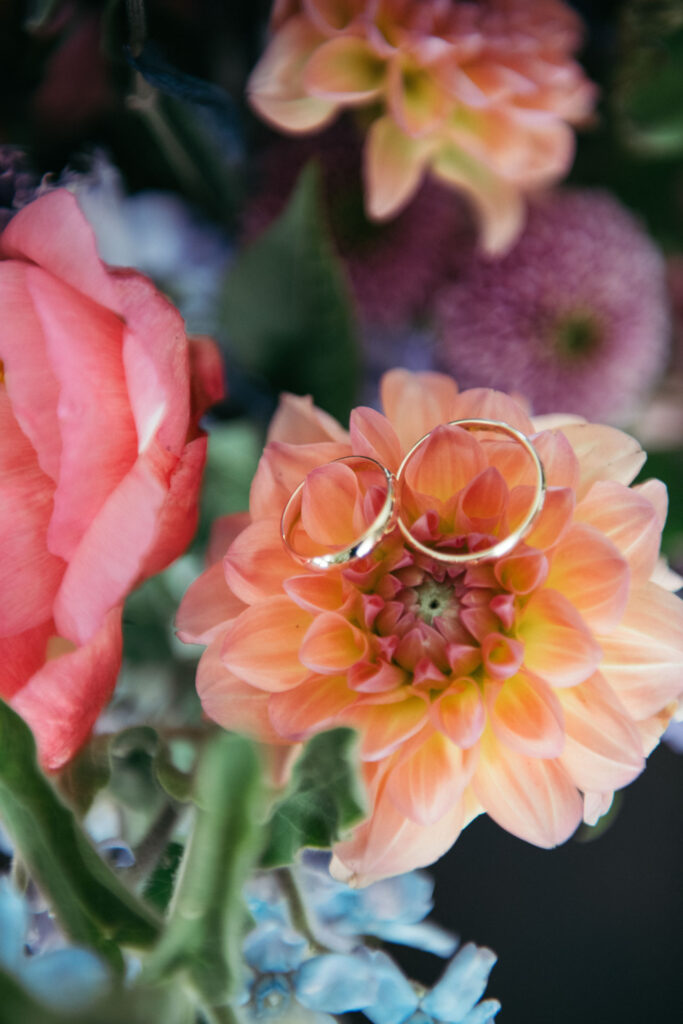 Wedding bands placed on colorful flowers, adding a touch of simplicity and charm to the symbol of eternal love in this Italo-Mexican celebration in Venice