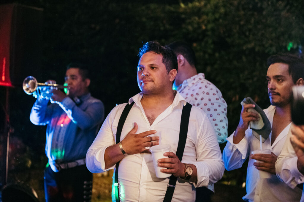 A guest captivated by the Mariachi music, listening with passion and joy as the vibrant melodies fill the air, enhancing the celebratory atmosphere