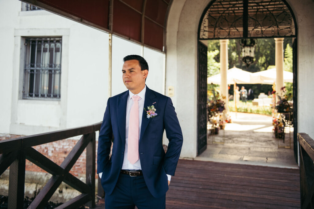 The groom waits with excitement for the first look photos, a moment filled with nerves and joy as he eagerly awaits the sight of his bride before the ceremony