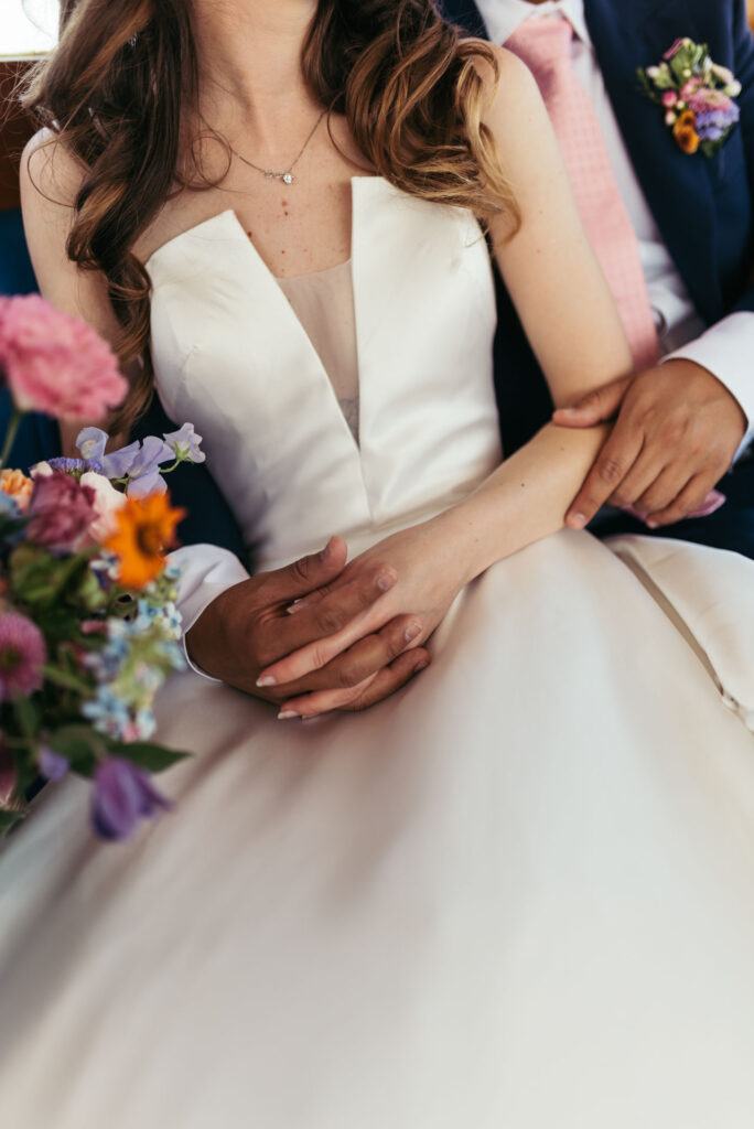 Enchanting portrait of the bride and groom on a water taxi, framed by the picturesque canals of Venice, capturing the romance of their journey to the wedding ceremony