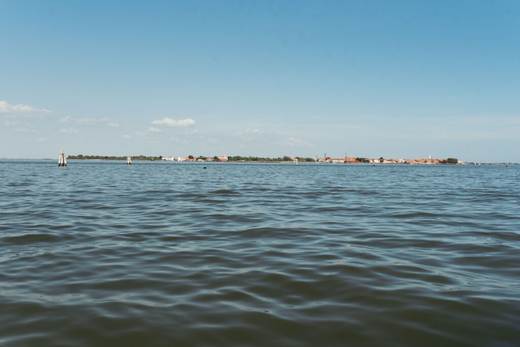 A breathtaking view of the Venetian Lagoon serves as a mesmerizing backdrop to the beautiful wedding celebration, with its serene waters reflecting the love and joy of the Italo-Mexican couple