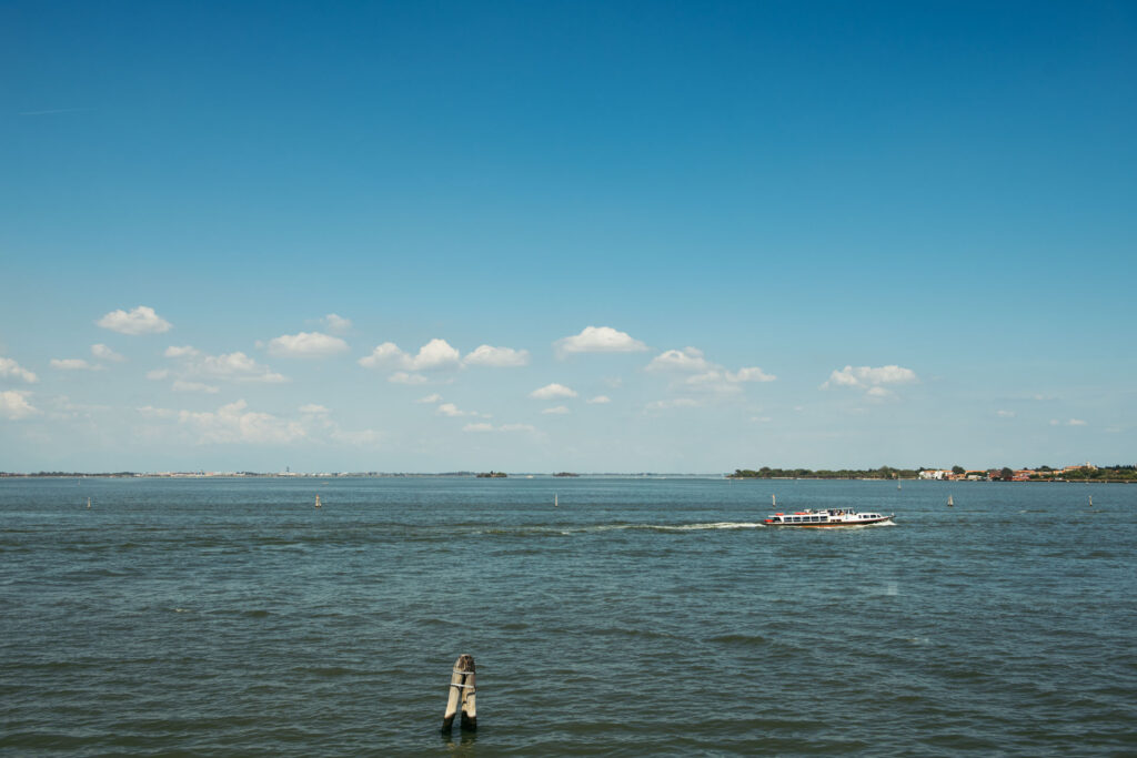 A breathtaking view of the Venetian Lagoon serves as a mesmerizing backdrop to the beautiful wedding celebration, with its serene waters reflecting the love and joy of the Italo-Mexican couple