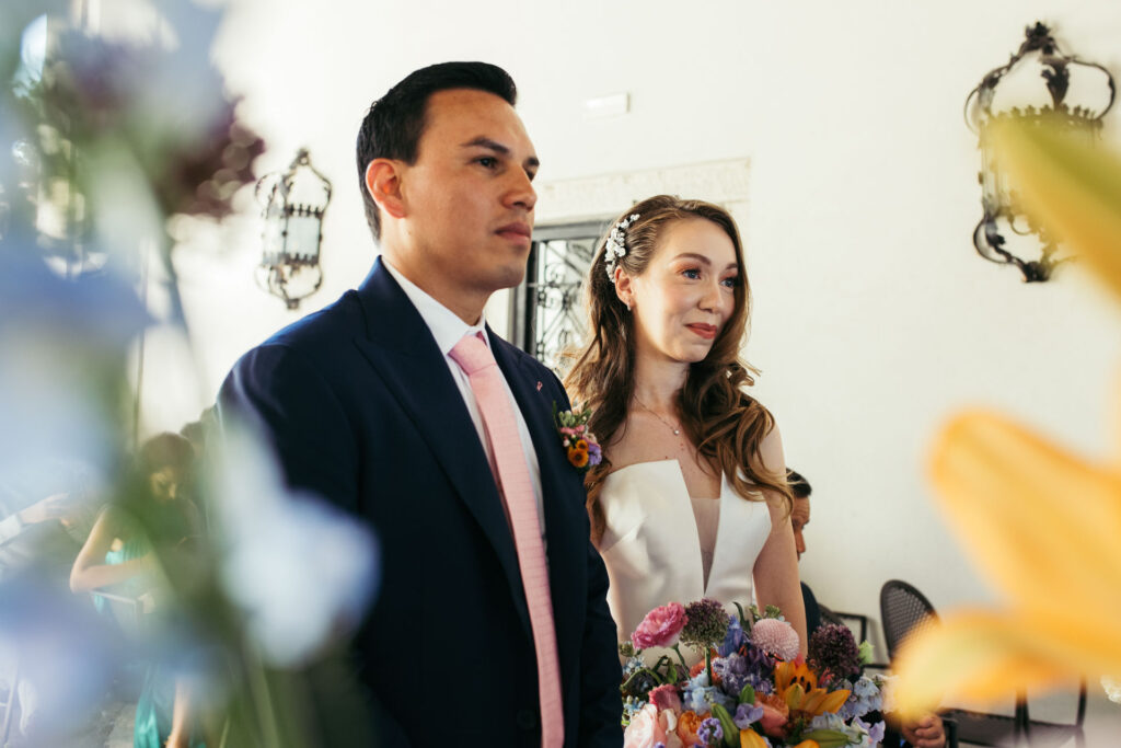 The bride and groom stand united, surrounded by the exquisite setting of the NH Collection Venezia Grand Hotel Palazzo dei Dogi, as they exchange vows in a moment of profound love and commitment