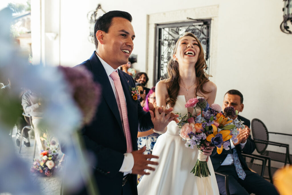 The newlyweds share a laughter-filled moment, radiating happiness as they embrace the joy of just being married