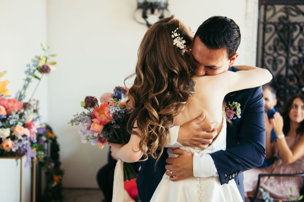 he bride and groom share a heartfelt hug, expressing the warmth and love that envelops them on their special day