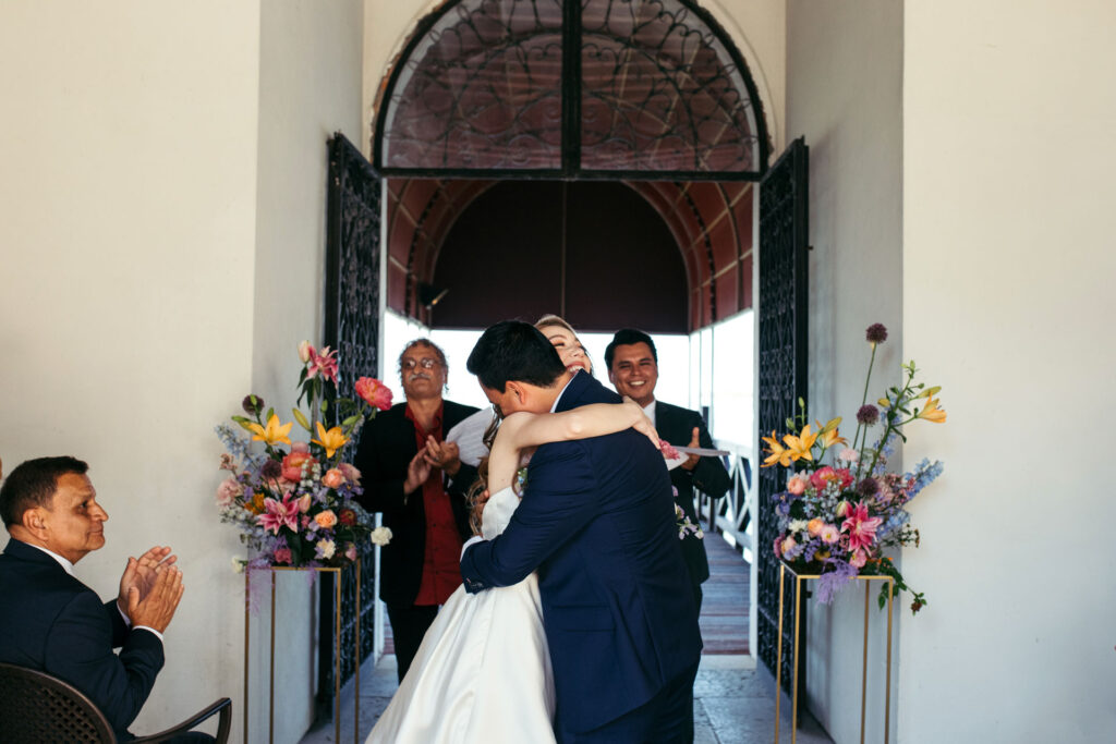 The bride and groom share a heartfelt hug, expressing the warmth and love that envelops them on their special day