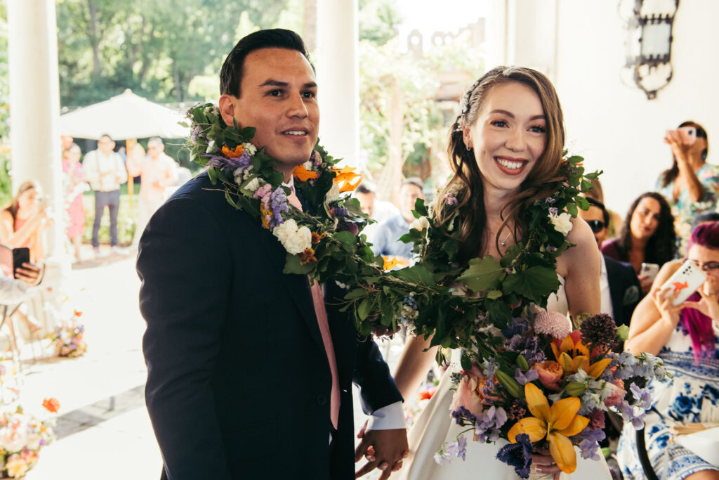 The bride and groom, adorned with the lazo, stand together in a moment symbolizing their eternal bond and shared commitment in marriage