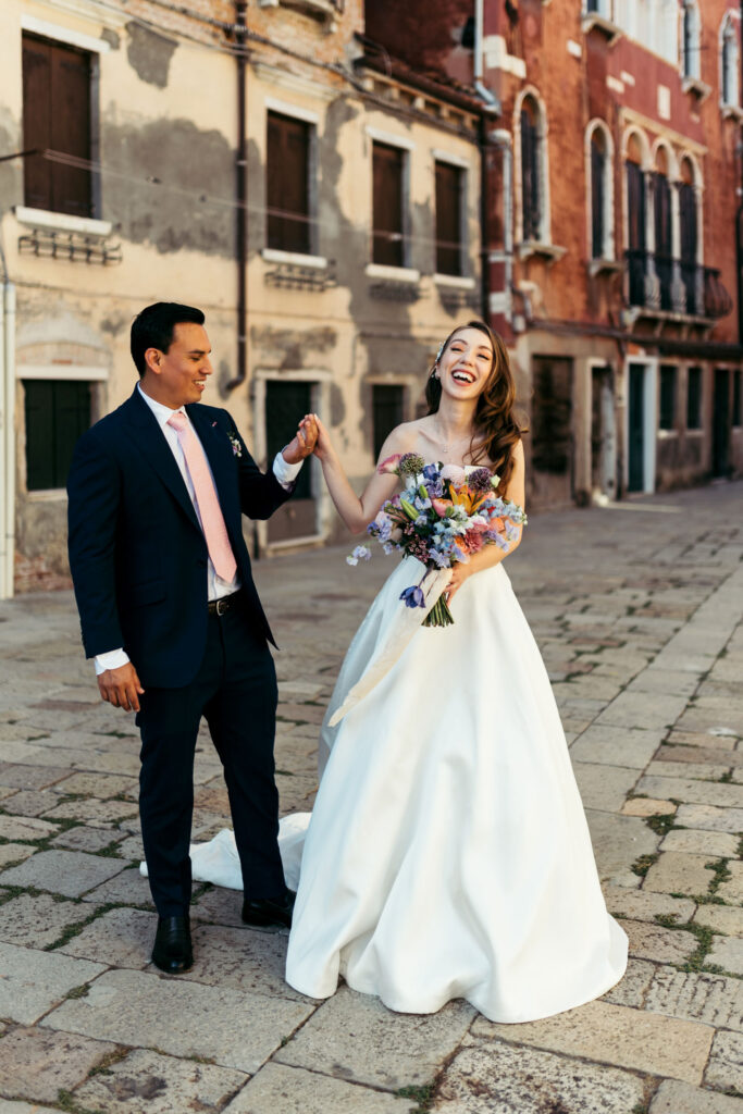 The bride and groom beam with happiness, creating a delightful and enchanting portrait against the backdrop of the picturesque canals of Venice