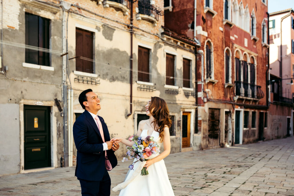 The bride and groom beam with happiness, creating a delightful and enchanting portrait against the backdrop of the picturesque canals of Venice