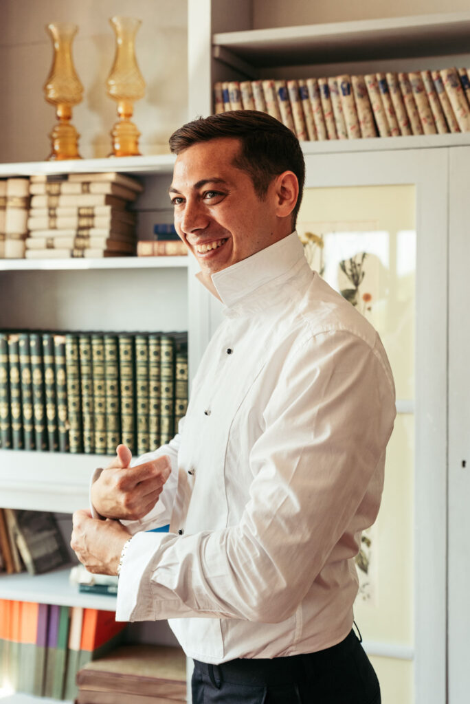 The groom smiles while getting ready