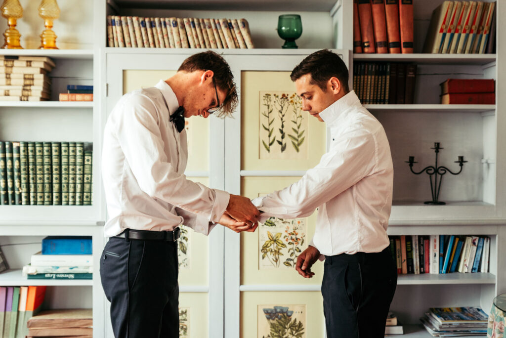 Best man helps groom buttoing his cufflinks