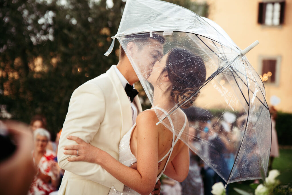 Bride and groom kiss under the umbrella after they got married