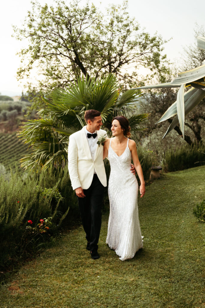 Bride and groom walk in the Tuscany countryside during bridal photoshoot