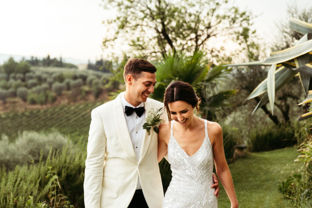 Newlywed couple smiles and laugh with joy while posing for the bridal photoshoot