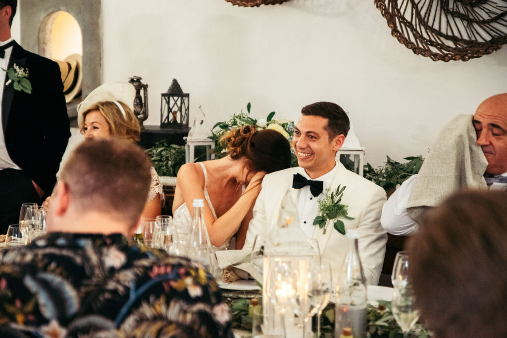 Bride and groom laugh during the speeches the guests are making