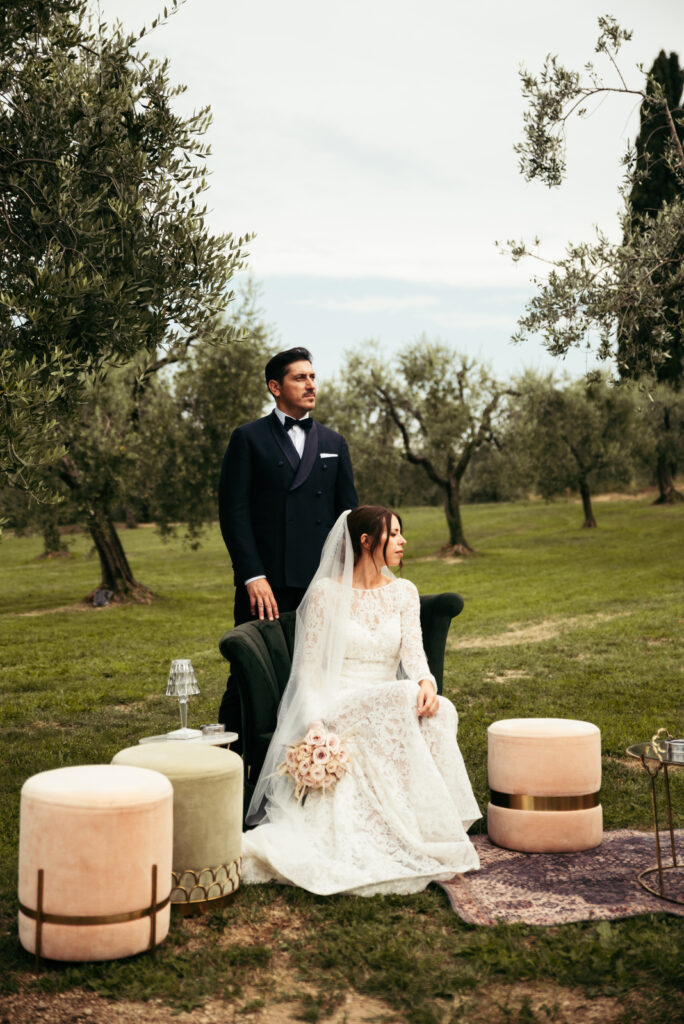 Bride and groom holding hands in the garden with olive trees of a villa in Salò