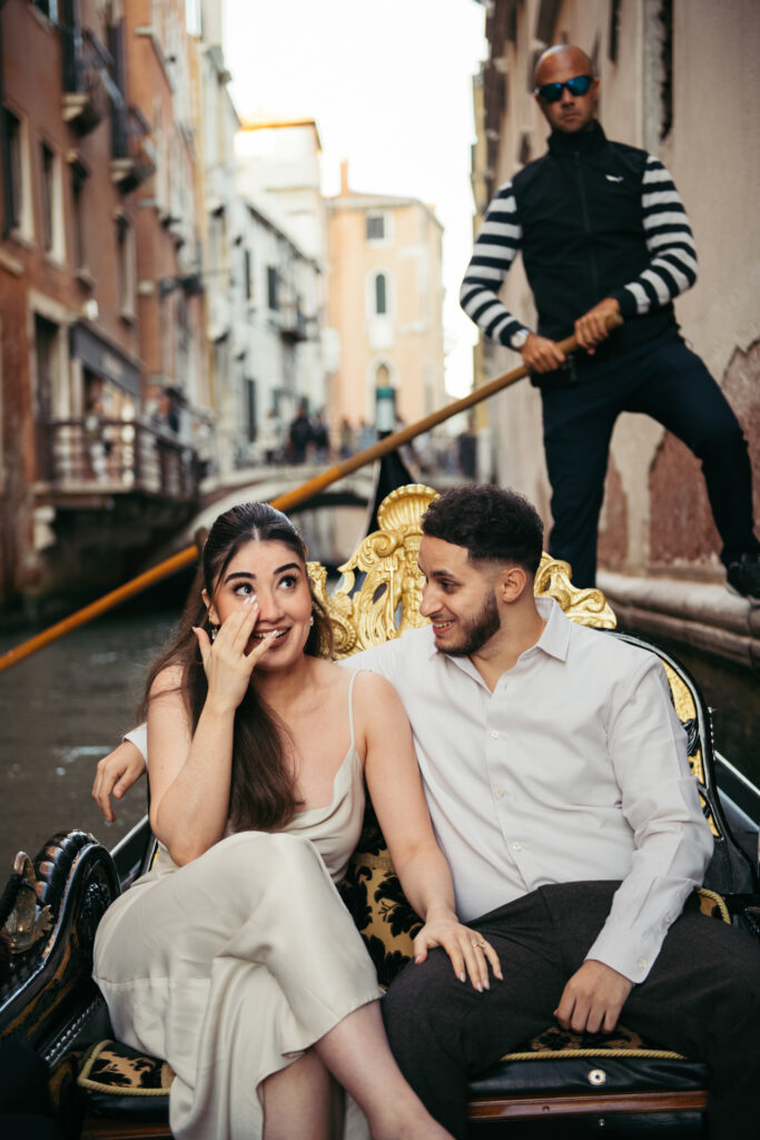 Girl drying a teardrop from her cheek after proposal on a gondola in Venice