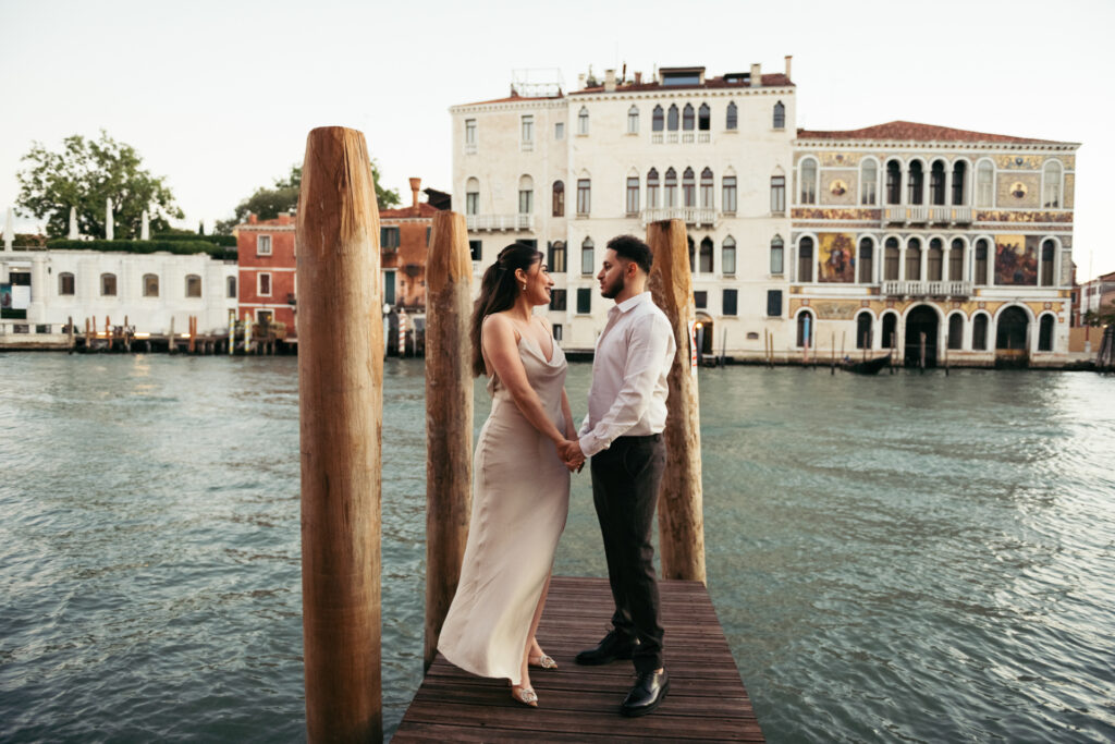 Newly engaged couple holding hands  posing for a Venice photoshoot