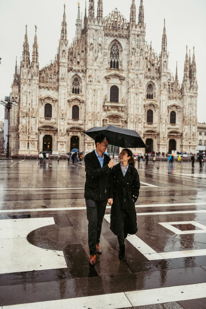 Couple walking in the rain with Milan's Duomo in the background
