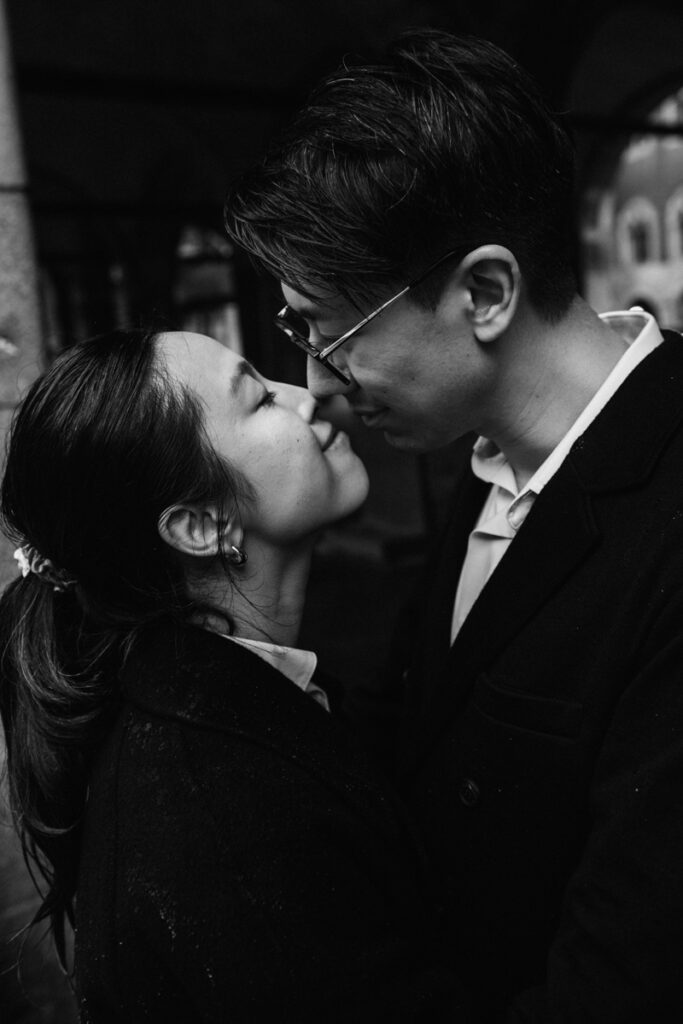 Close-up black and white portrait of a couple kiss