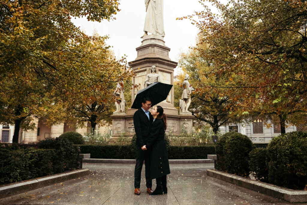 Couple hugging in Piazza della Scala during an autumn rainy day