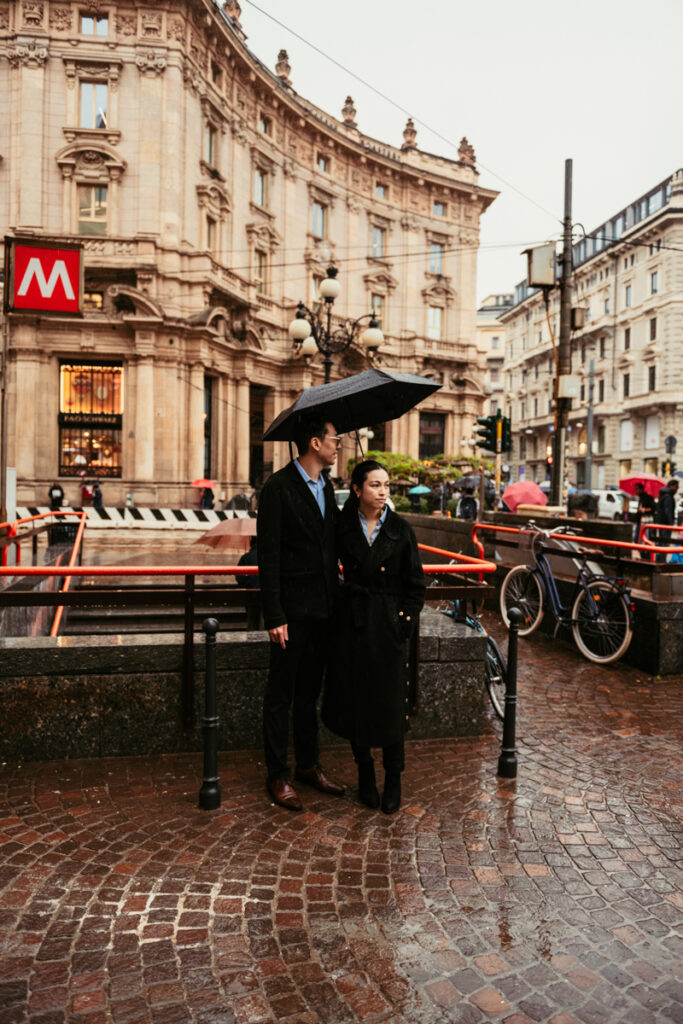 Couple posing in front of metro station in Cordusio square, Milan
