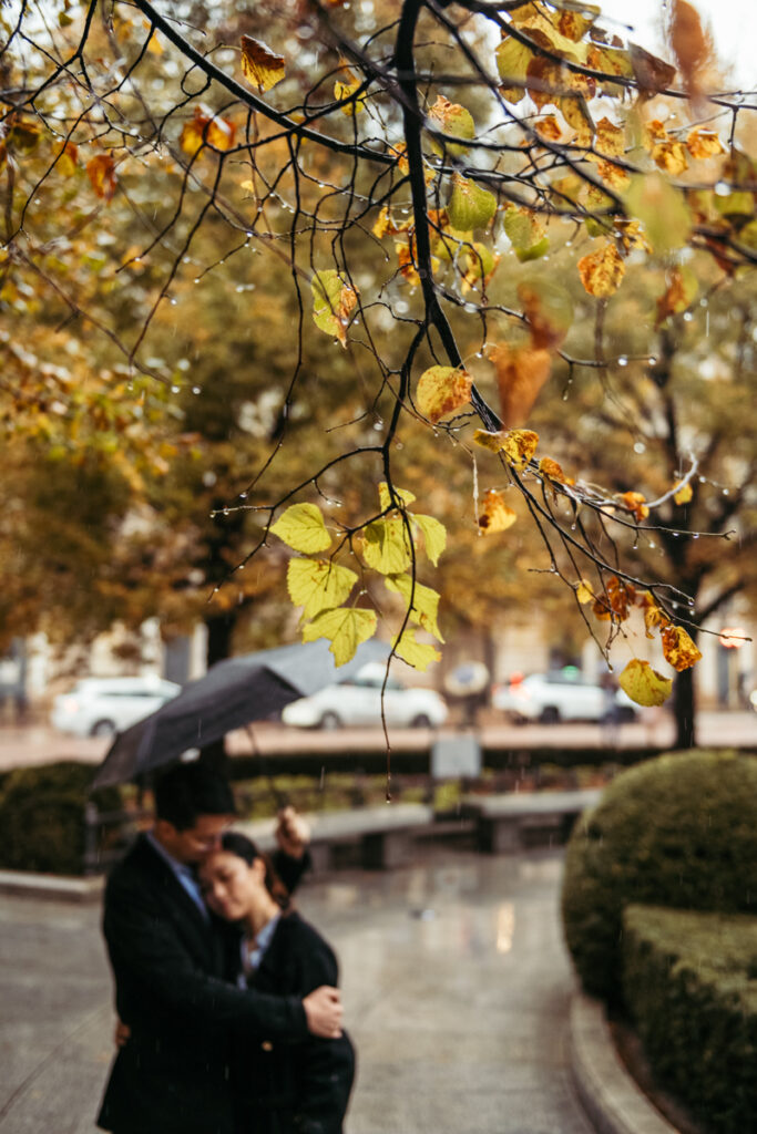 Couple hugging under the rain during an autumn day in Milan, Italy