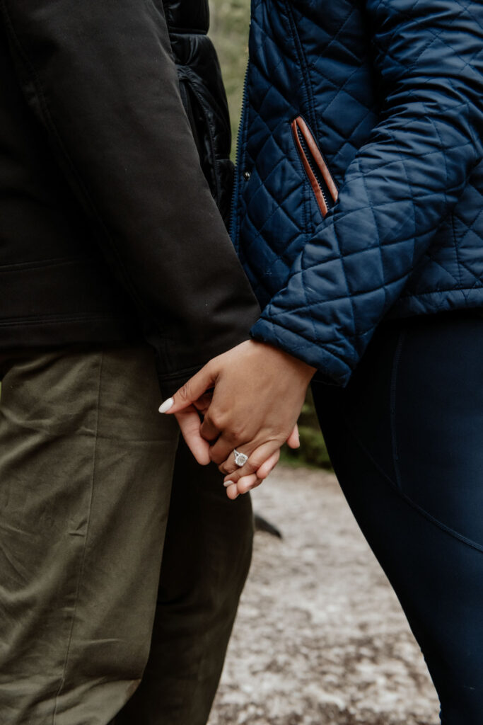 Holding hands with engagement ring during a Lake Braies engagement photoshoot