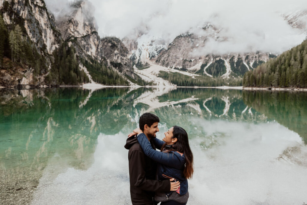 Couple smiles with happyness after he proposed to her at Lake Braies, Dolomites