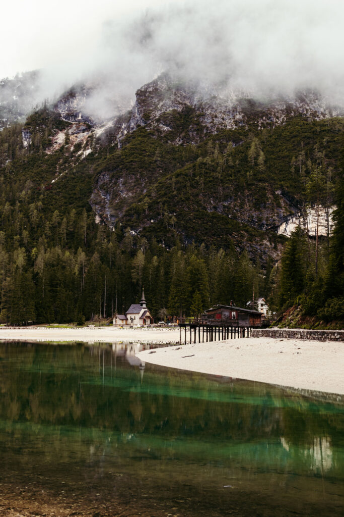 Vertical panoramic photo of Lake Braies and its small church