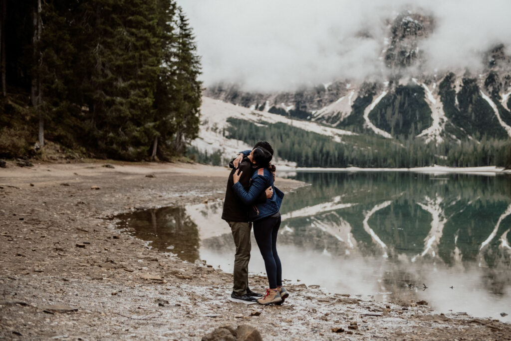 Couple hugging after getting engaged at Lake Braies in Dolomites, Italy