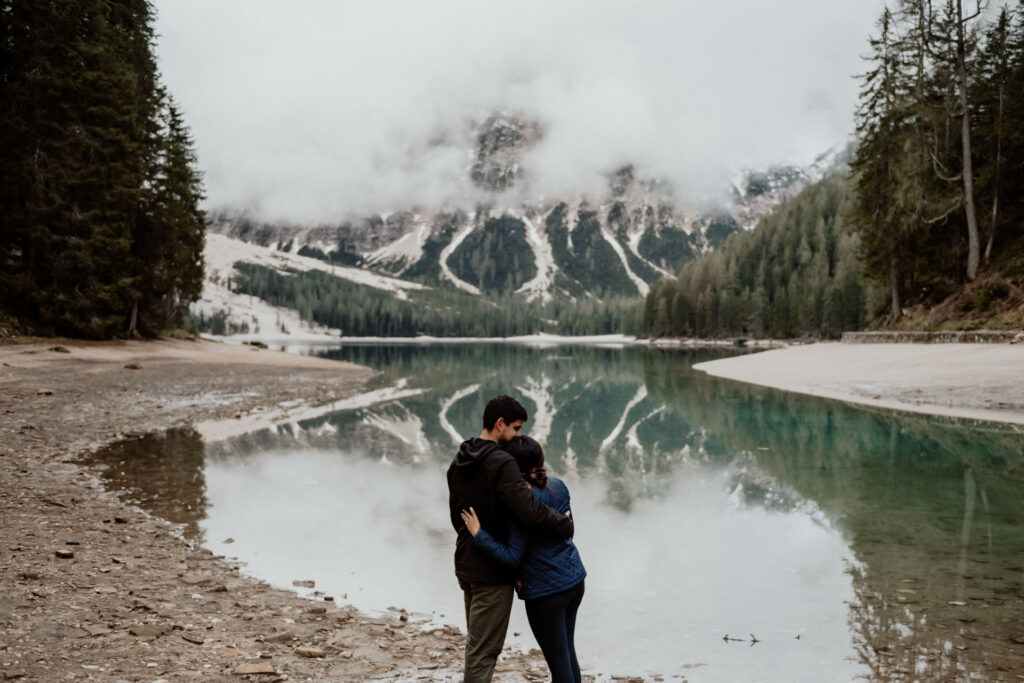 Couple hugging after proposal at Lake Braies in Dolomites, Italy