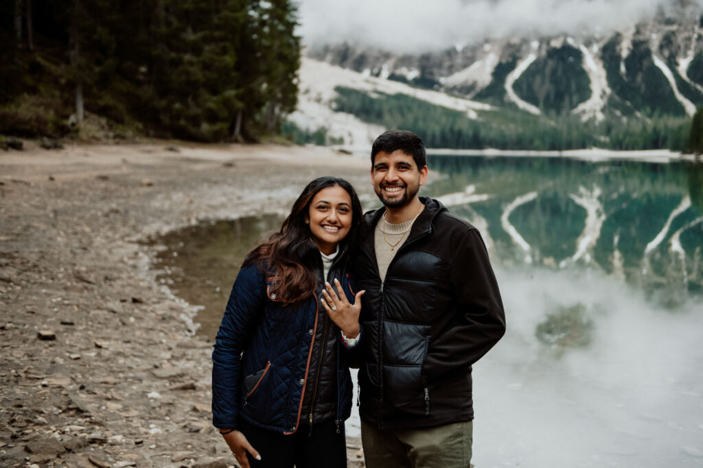 Couple showing the ring after getting engaged at Lake Braies in Dolomites, Italy