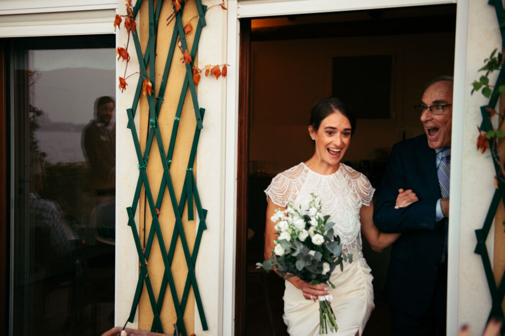 Bride and her dad arrive on the terrace smiling with happyness