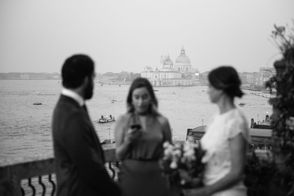 Black and white photo of the Wedding ceremony on a small terrace overlooking Venice lagoon at sunrise