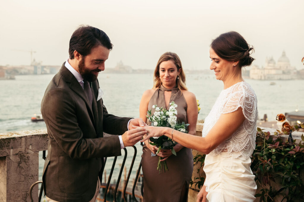 Groom putting on the bride's hand the wedding band