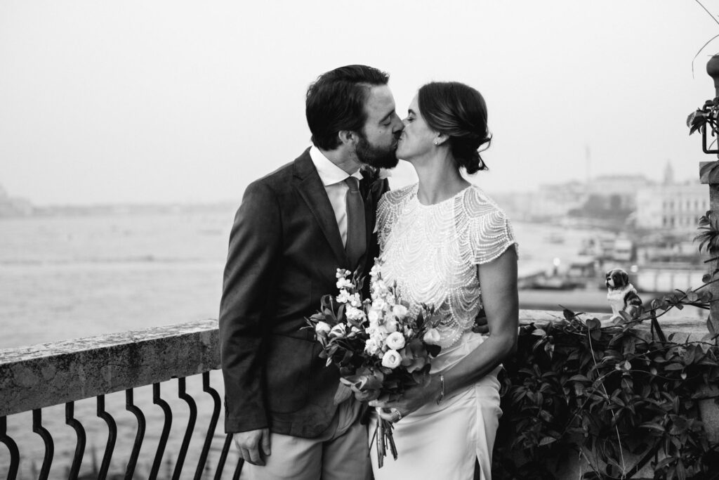 Black and white photo of bride and groom kissing