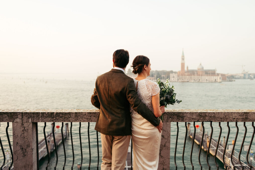 Bride and groom from the back while they observe the Venetian lagoon