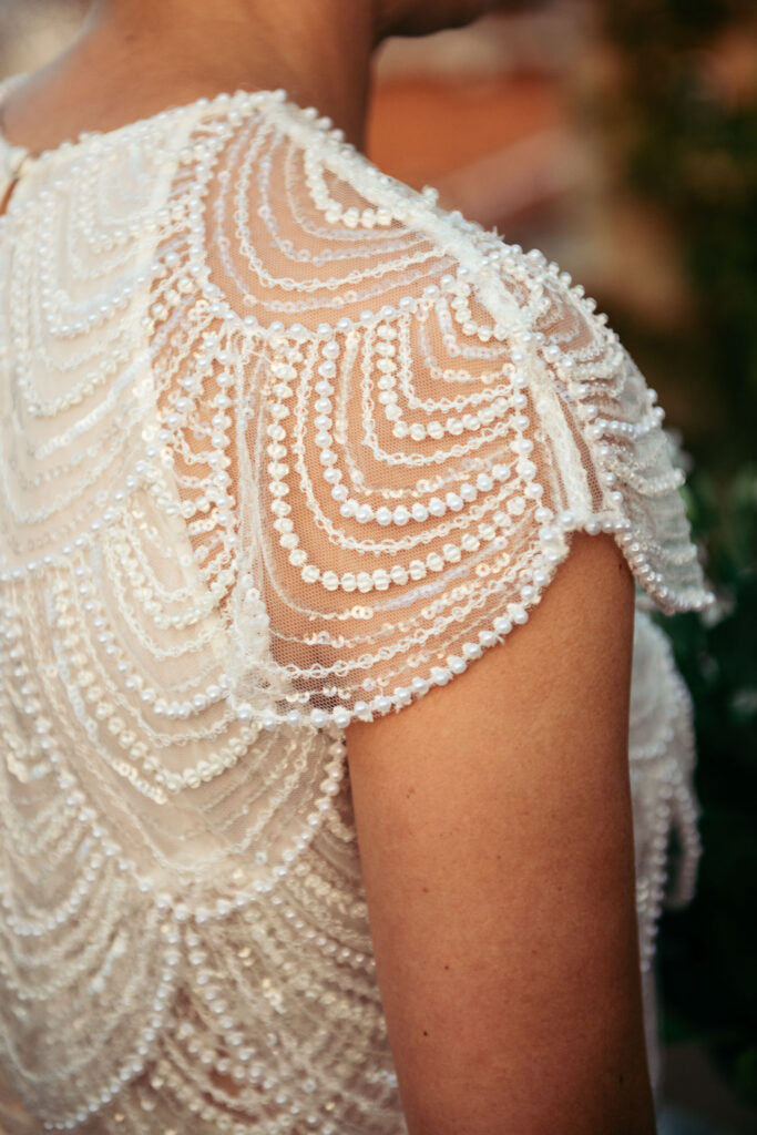 Close up of the bride's dress with a lot of white beads