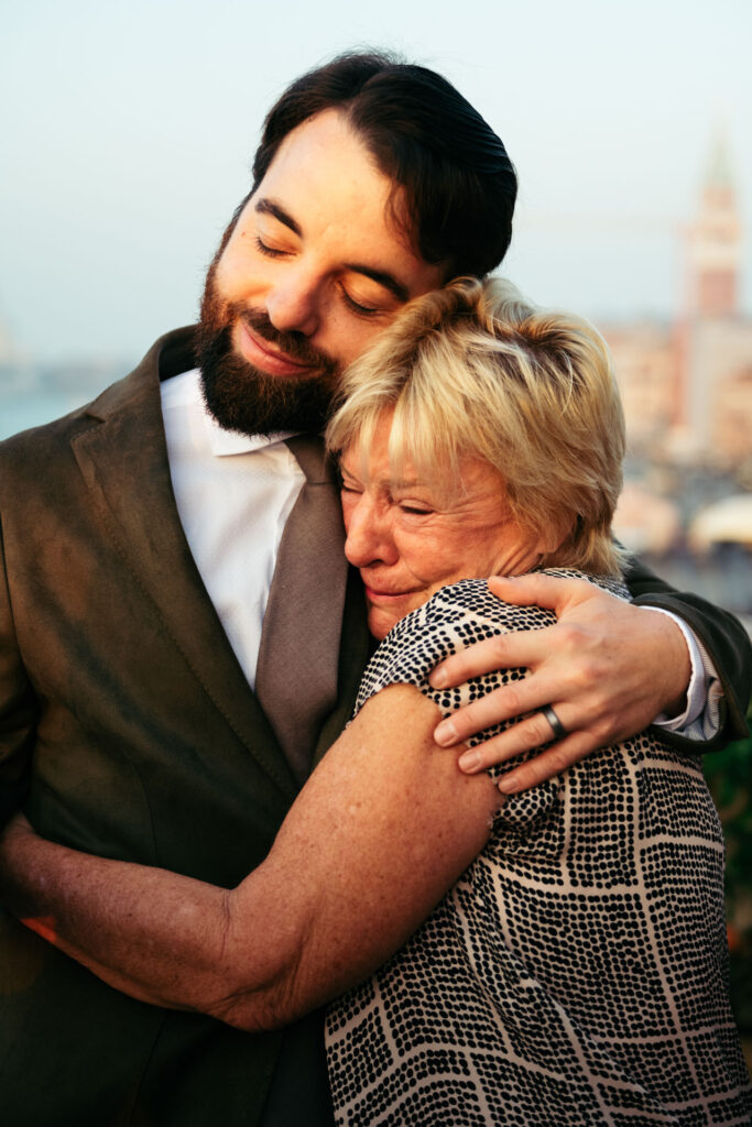 The groom is hugging his moved mum