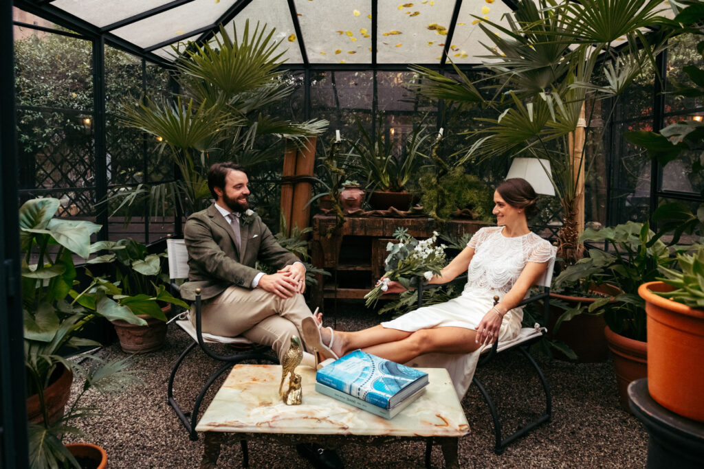 Bride and groom posing in a greenhouse