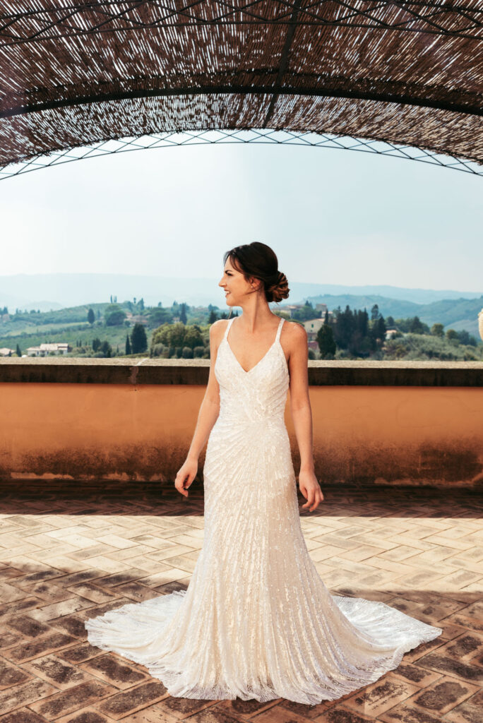 Bride is ready and poses against the stunning Tuscany hills background