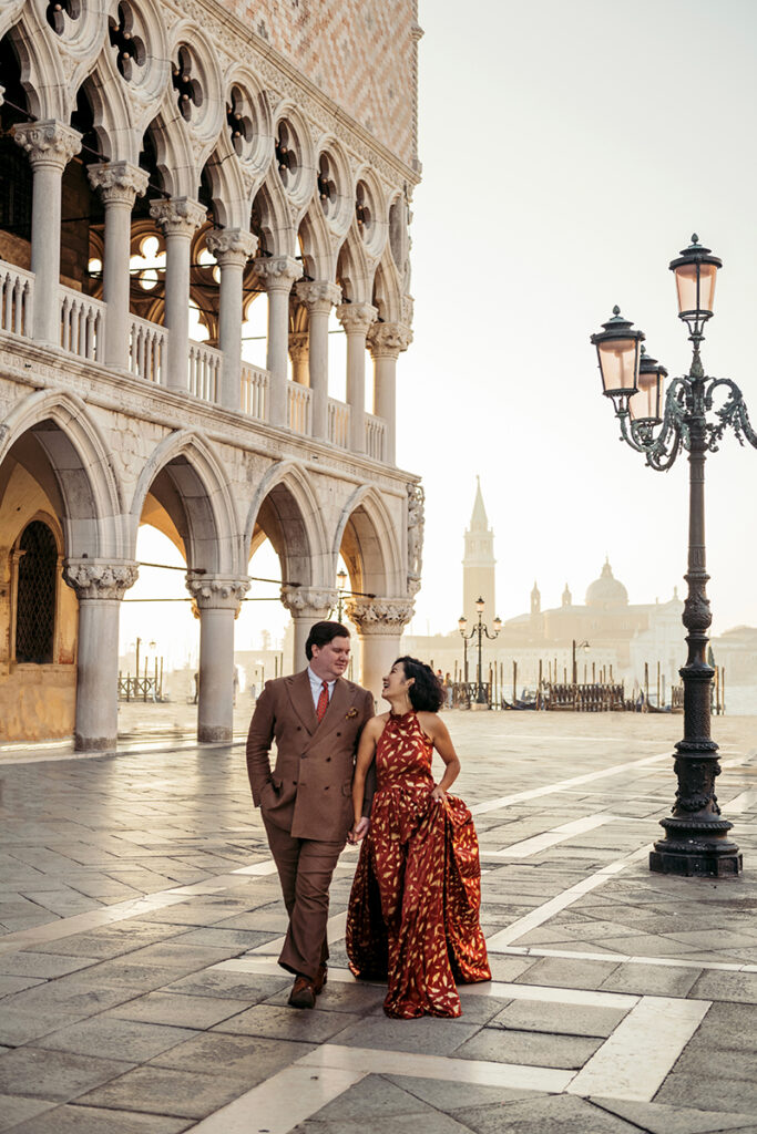 Couple walking in front of Doge Palace in Venice at sunset