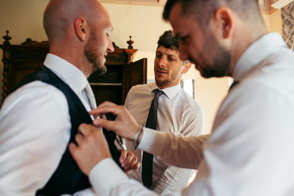 Groom and friends getting prepared before wedding ceremony in Langhe, Piedmont