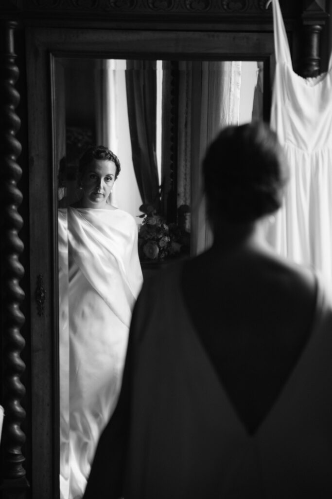 The bride looks herself in the mirror