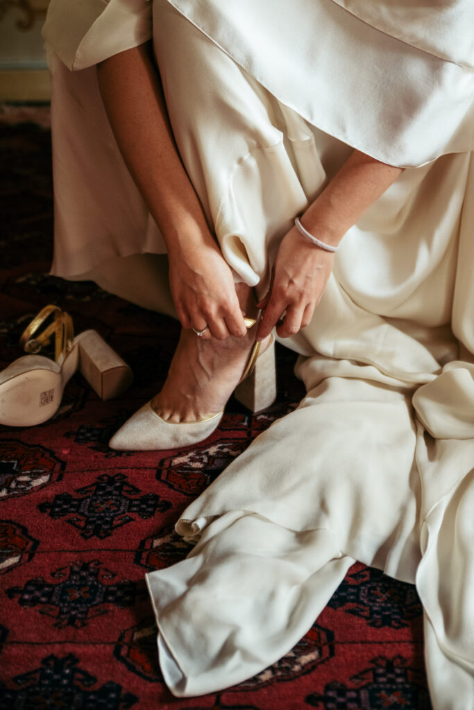 Close-up of the bride wearing wedding shoes