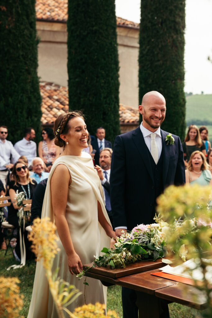 Bride and groom smiling at wedding ceremony in the vineyards of Langhe